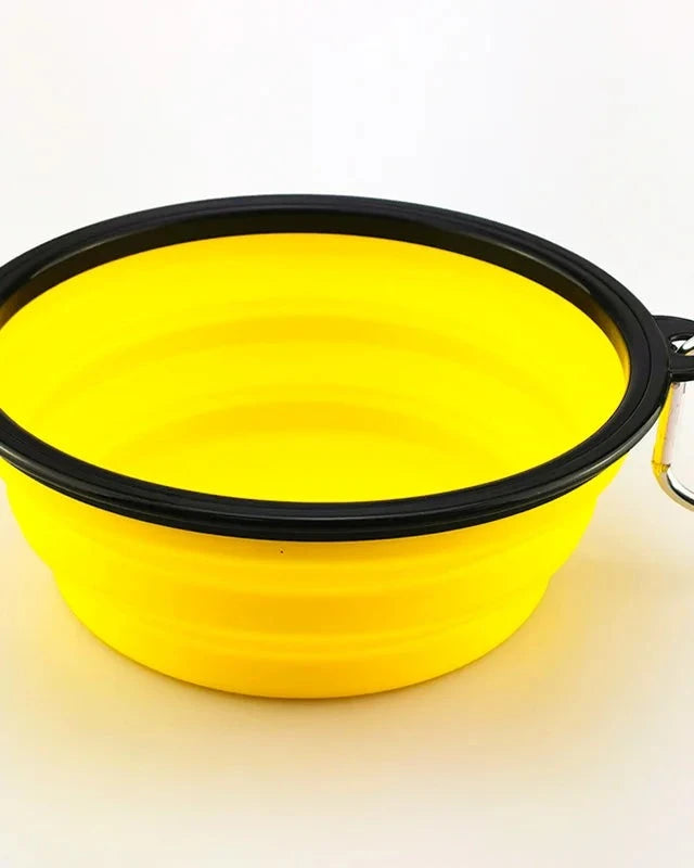 The Fold-Flat Bowl in yellow with carabiner on a white background