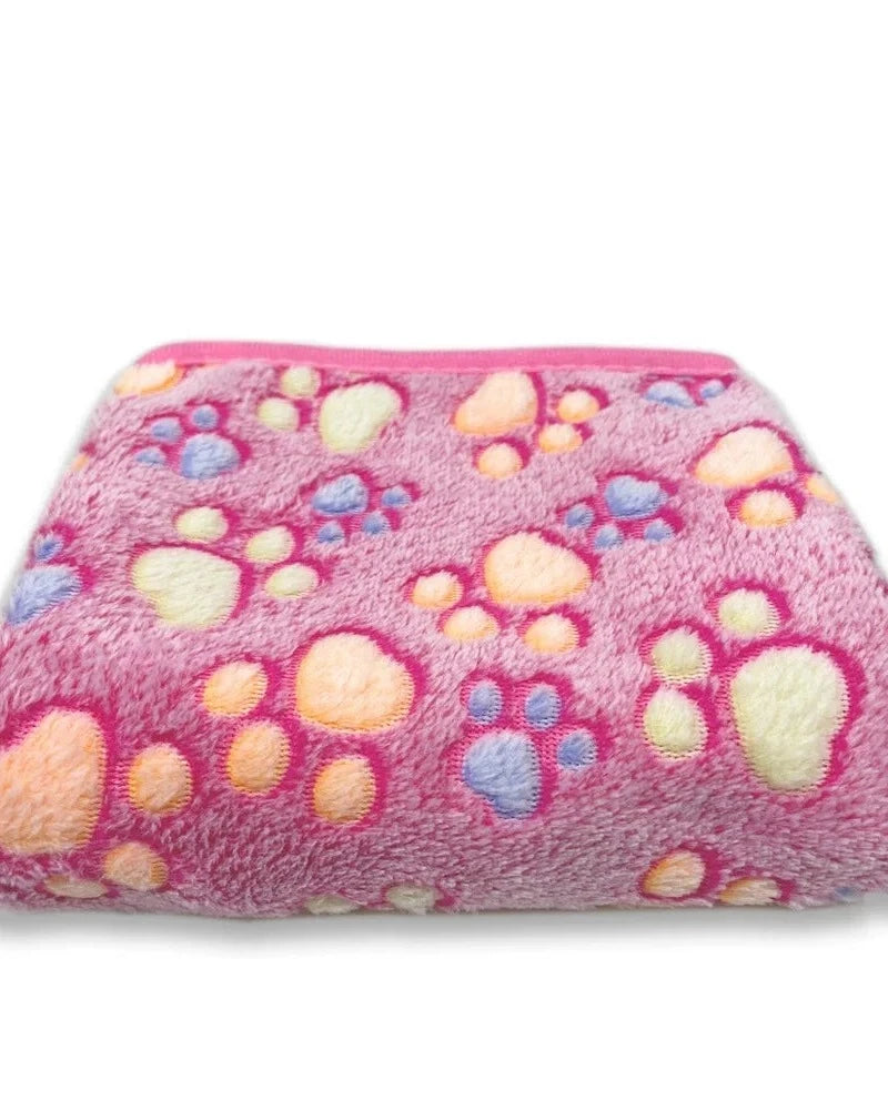 The Sunday Blanket in pink with paw print, folded, on a white background