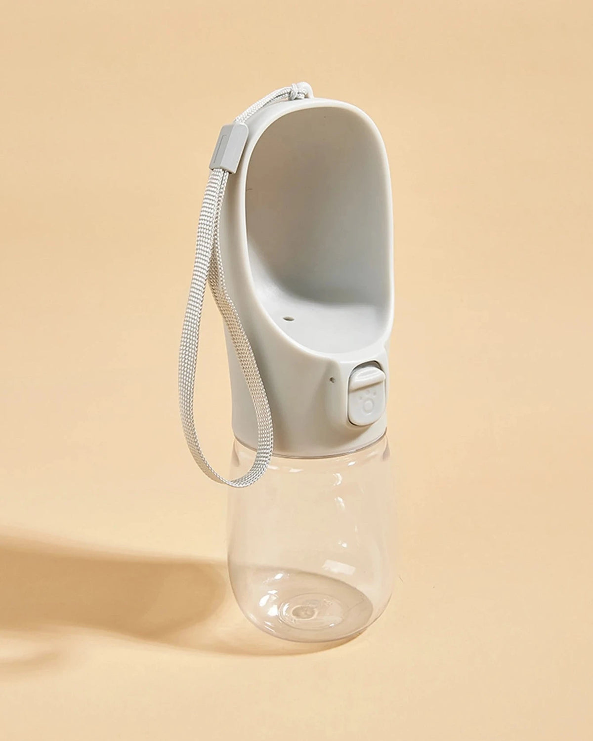 The Long Walk Water Bottle in grey with wrist strap on a cream background