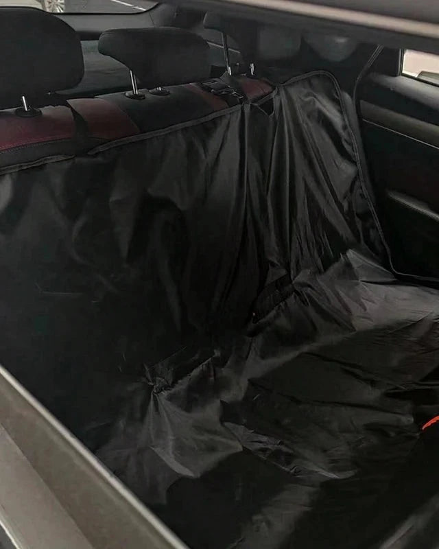 The Back Seat Cover in black fitted across a car's back seat