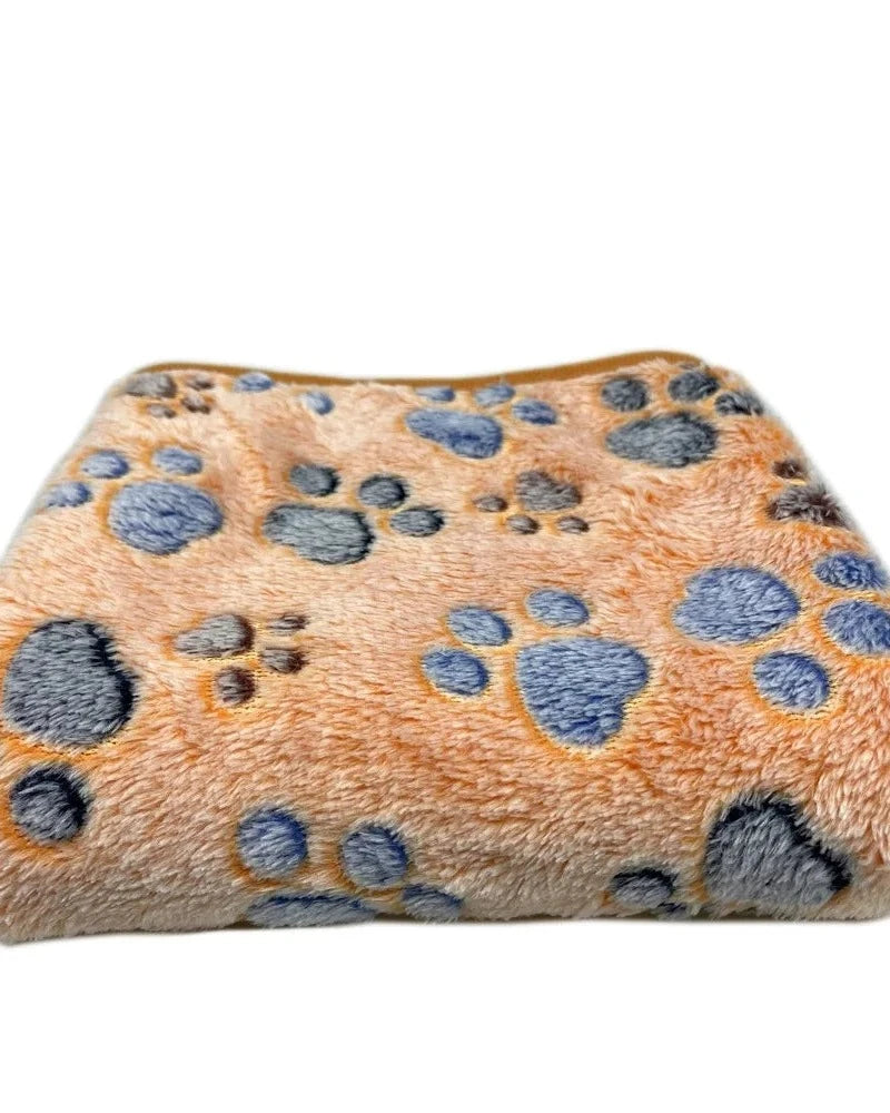 The Sunday Blanket in tan with paw print, folded, on a white background