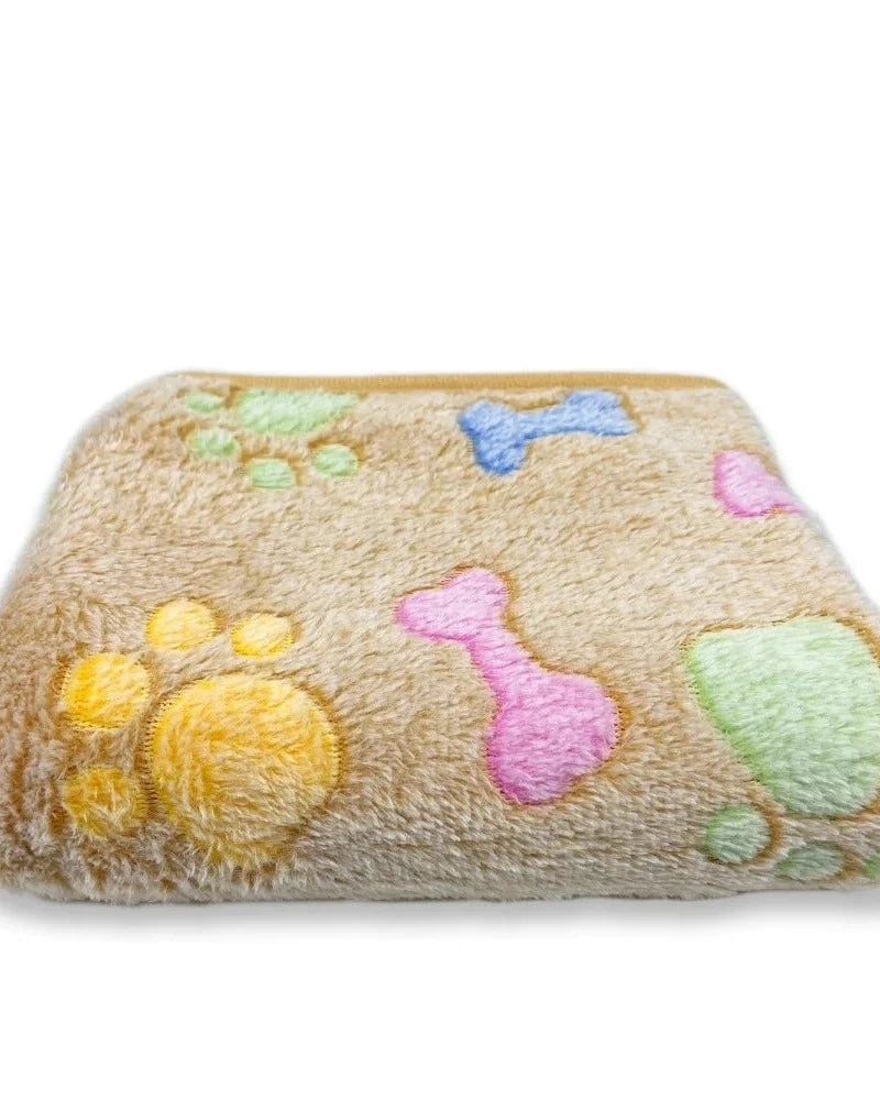 The Sunday Blanket in beige with bone print, folded, on a white background
