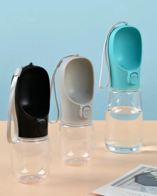 The Long Walk Water Bottle in black, cream and turquoise on a sand-coloured table